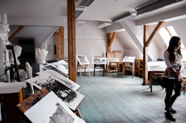 A view of a vibrant art studio filled with a diverse collection of paintings and sculptures.